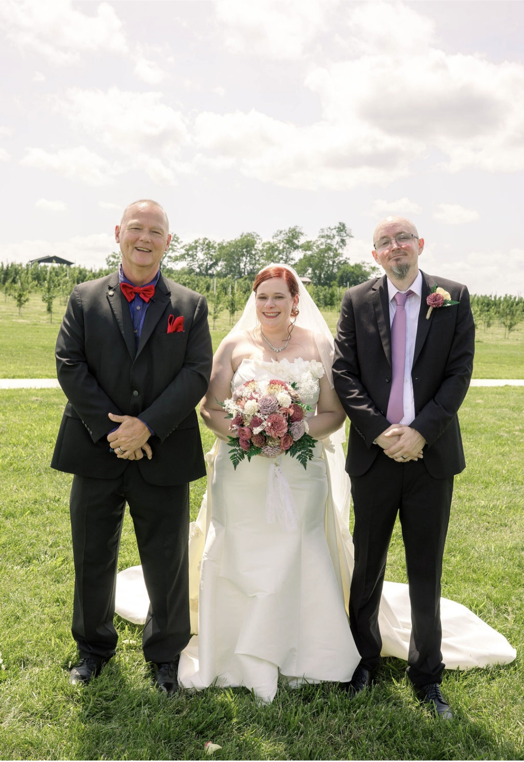 Kevin with bride and groom at outdoor vineyard ceremony